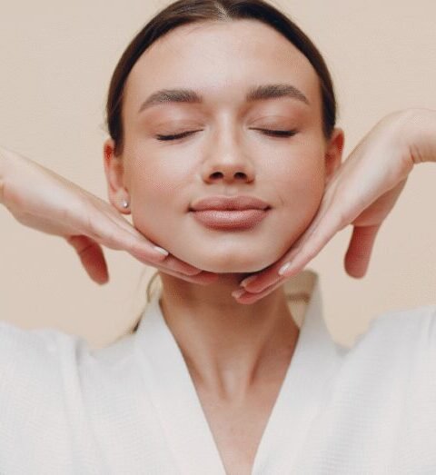 Woman with her eyes closed gently framing her face with her hands