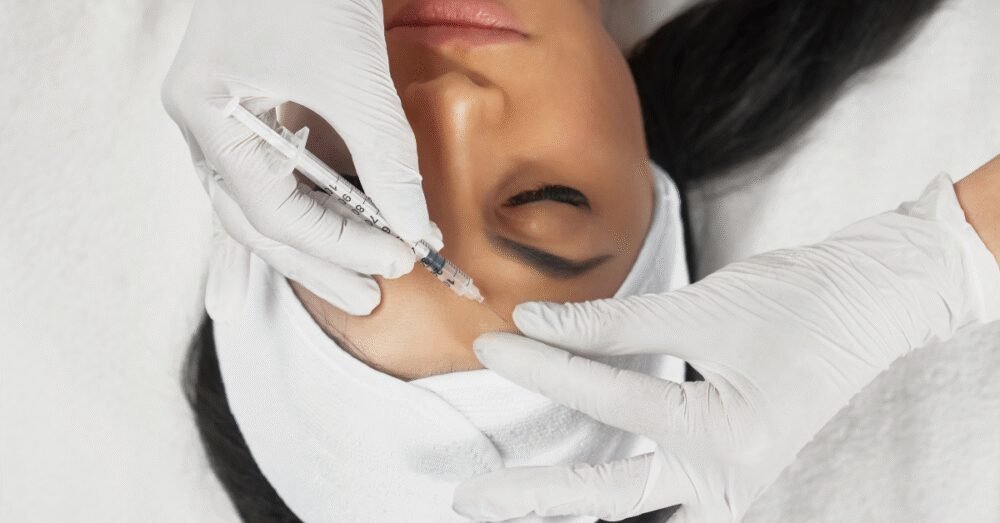 Woman lying down while receiving injectable treatment on her forehead